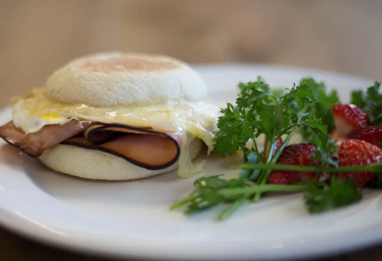 A breakfast sandwich with egg on a plate